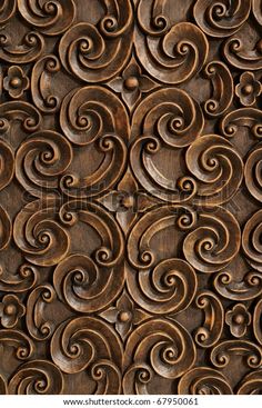 an intricate carved wood panel with swirls and circles on it's surface, in brown