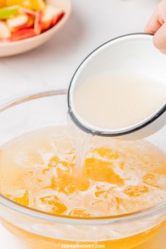 a person pours milk into a glass bowl