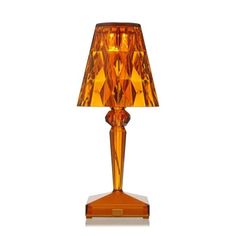 an orange glass lamp with a brown shade on the base and a gold colored lampshade