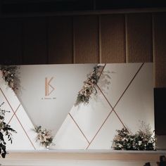 a stage set up with flowers and greenery