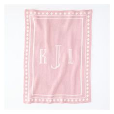 a pink and white towel with the letter jl on it's front corner