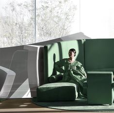 a woman sitting on top of a green couch