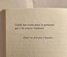 an open book with some writing on the pages and words written in french above it