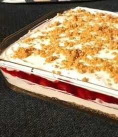 a cake with white frosting and crumbs on top sitting on a table