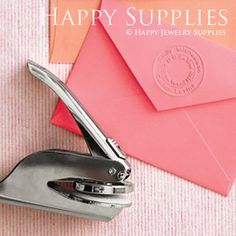 a pair of scissors and some pink envelopes