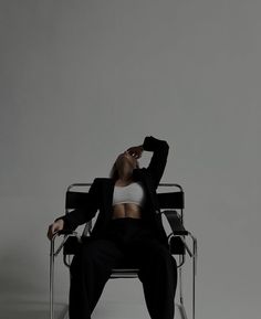 a woman sitting in a chair with her hands behind her head