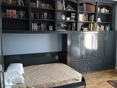 a bed sitting in a bedroom next to a book shelf