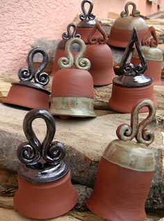 several small bells are sitting on top of some wood and metal pieces that look like they have been made from clay