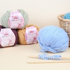 several balls of yarn and knitting needles on a table