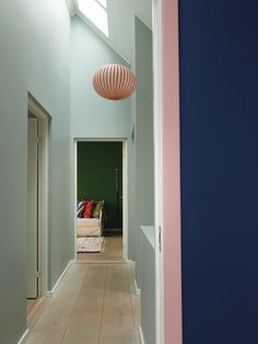 an empty hallway with blue walls and pink accents