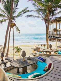 the beach is lined with palm trees and lounge chairs, which are set up on wooden planks