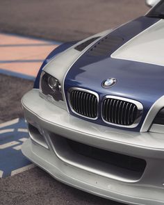 the front end of a blue and white sports car