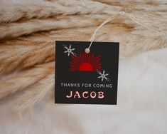 a black and red tag hanging from a fur covered bed with the words thanks for coming jacob