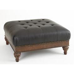 a black leather ottoman sitting on top of a wooden frame