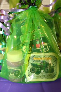 a green bag filled with candles on top of a purple table next to other items