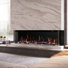 a modern fireplace in the middle of a living room with marble walls and flooring