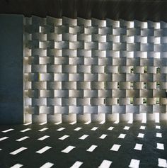 an empty room with white squares on the wall and sunlight coming through the window onto the floor