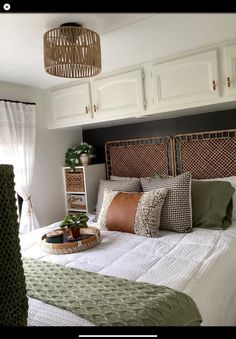 a bed that has some pillows on top of it in a room with white cabinets