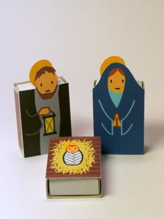 three paper nativity figures sitting next to each other