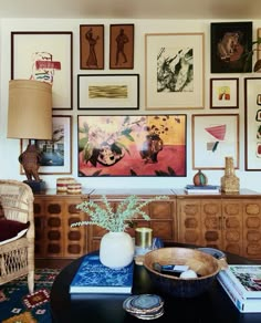 a living room filled with lots of pictures on the wall above a coffee table and chair