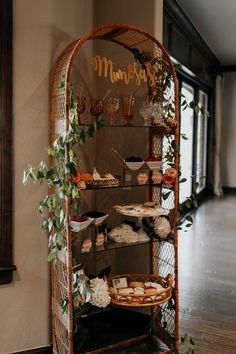 a display case filled with lots of food on top of a wooden floor next to a window