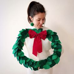 a woman wearing a christmas wreath made out of paper