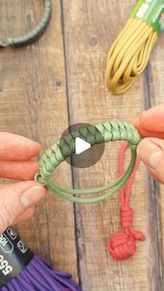 someone is tying a paracording cord on a wooden table with other items in the background