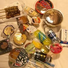 many different types of food on a white tablecloth with chopsticks and forks