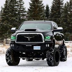 a large black truck parked in the snow