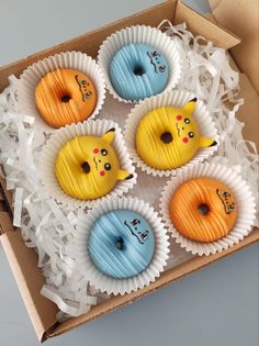 six decorated doughnuts are in a box