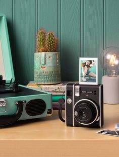 an old - fashioned camera, record player and other items sit on a table