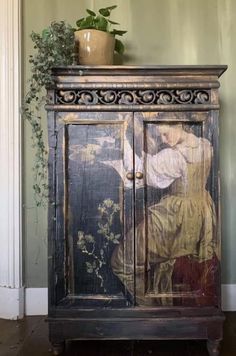 an old painted cabinet with a potted plant on top