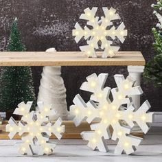 lighted snowflakes sitting on top of a wooden table