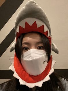 a woman wearing a face mask with a shark on it's head and mouth