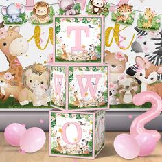 a pink and green jungle animal themed birthday party with balloons, streamers and decorations