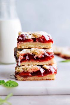 three strawberry shortcakes stacked on top of each other next to a glass of milk