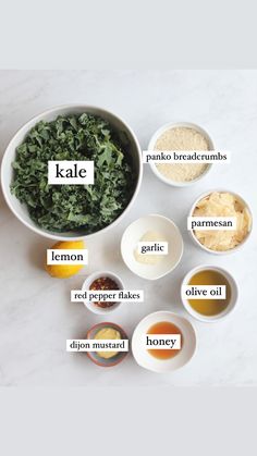 the ingredients for kale salad in bowls on a marble counter top with their names