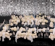 white flowers and candles are hanging from the ceiling