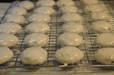 doughnuts are cooling on a wire rack in the process of being glazed with icing