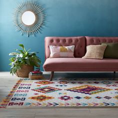 a living room with blue walls and a pink couch