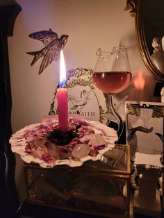 a candle that is on top of a table with some wine glasses in front of it