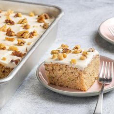 a piece of cake sitting on top of a plate next to a pan filled with frosting