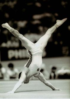 a man doing a handstand in front of an audience