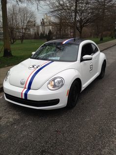 a white sports car with red, white and blue stripes on it's side