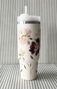 a coffee cup sitting on top of a table next to a striped wallpapered background