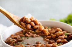 a spoon full of beans is being held up