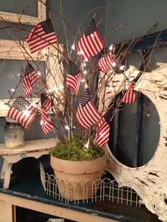 a potted plant with american flags on it sitting on a table next to a mirror