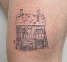 a small tattoo of a house on the thigh