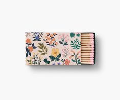 matches in a floral box with pink and yellow flowers on the front, and green leaves on the back