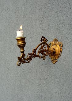 This beautiful Art Nouveau style candleholder was made in the 1960s, made out of solid brass. This would look great somewhere in your home for everyone to admire, hangs with one nail or screw. In great vintage state, ready to use, would look extra dramatic with a dark red or black candle. The brass has patina due to its age. This has a total height of 5'' (12.5 cm), 3'' (7.5 cm) wide and 9'' (23 cm) deep.   Will be shipped by Registered mail, which includes tracking. Please note that we often use recycled packaging materials, especially for larger pieces. They are safe and strong and are eco friendly which is good for our environmental consciousness but are often not very pretty. If you are buying an item as a gift please leave a note during checkout and we will make sure that the packagin Wall Candle Holder, Environmental Consciousness, Wall Candle, Art Nouveau Decor, Black Candle, Vintage Wall Sconces, Red Or Black, Wall Candle Holders, Art Nouveau Style